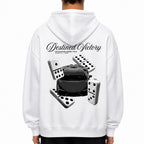 A person shown from the back wearing a white hoodie with a large black and gray graphic print on the back featuring the words 'Destined Victory' and several dominoes surrounding a black car. 