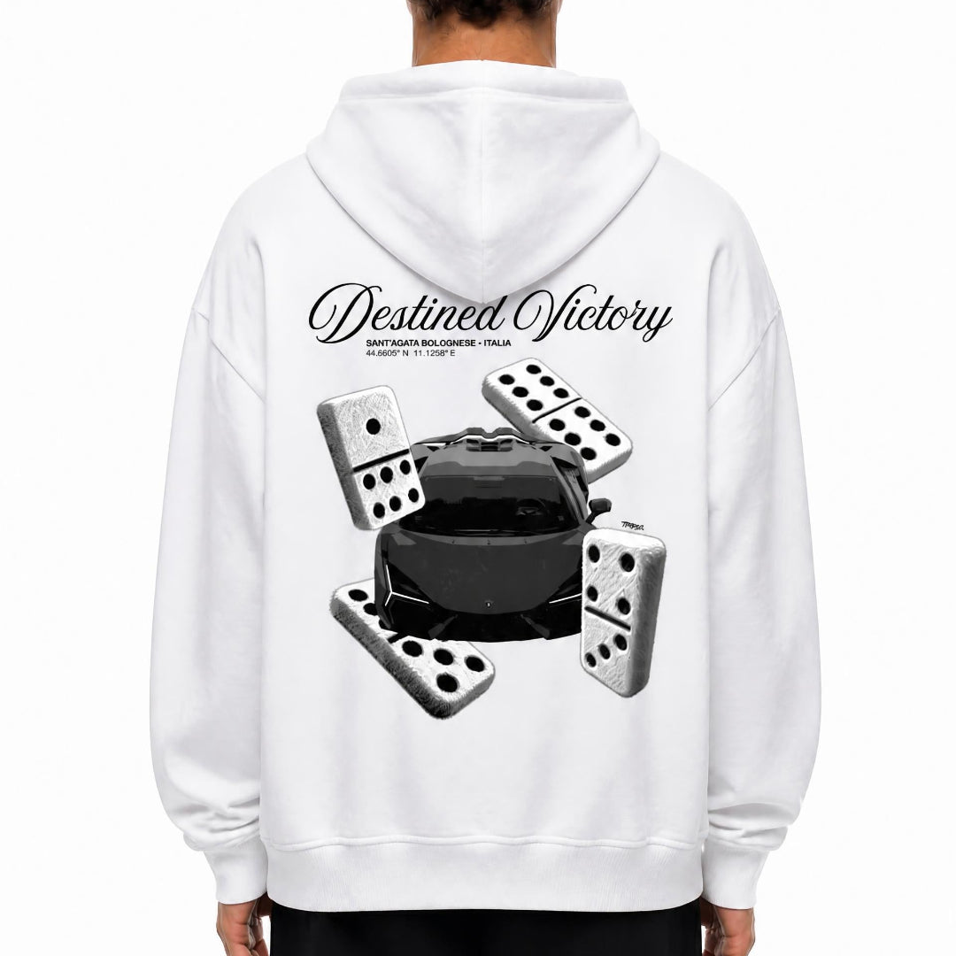 A person shown from the back wearing a white hoodie with a large black and gray graphic print on the back featuring the words 'Destined Victory' and several dominoes surrounding a black car. 